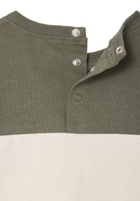 Gestreiftes Hemd aus grünem und cremefarbenem Stoff mit geripptem Kragen, zwei Druckknöpfen und einer glatten Textur. Das Design weist ein Blockfarbendesign auf.