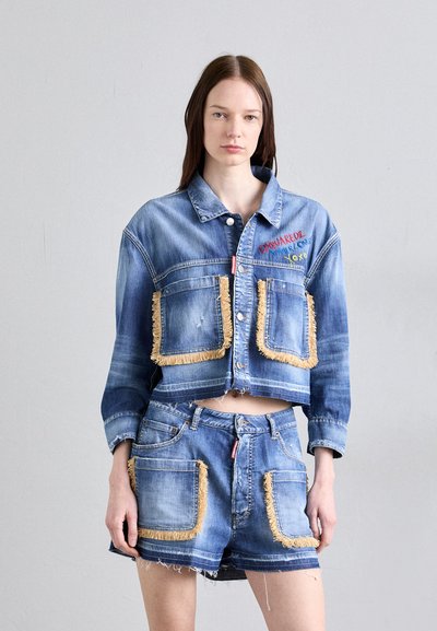 Jachetă din denim cu buzunare accentuate de franjuri și design scurt, asortată cu pantaloni scurți din denim cu margini desfăcute și marginile buzunarelor în contrast.