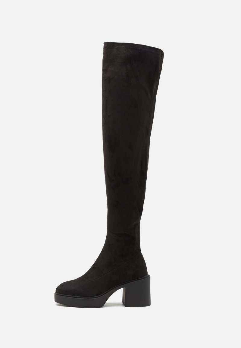 Botas pretas acima do joelho feitas de camurça macia, com um salto robusto e design elegante, apresentando uma textura suave e sem padrões visíveis.