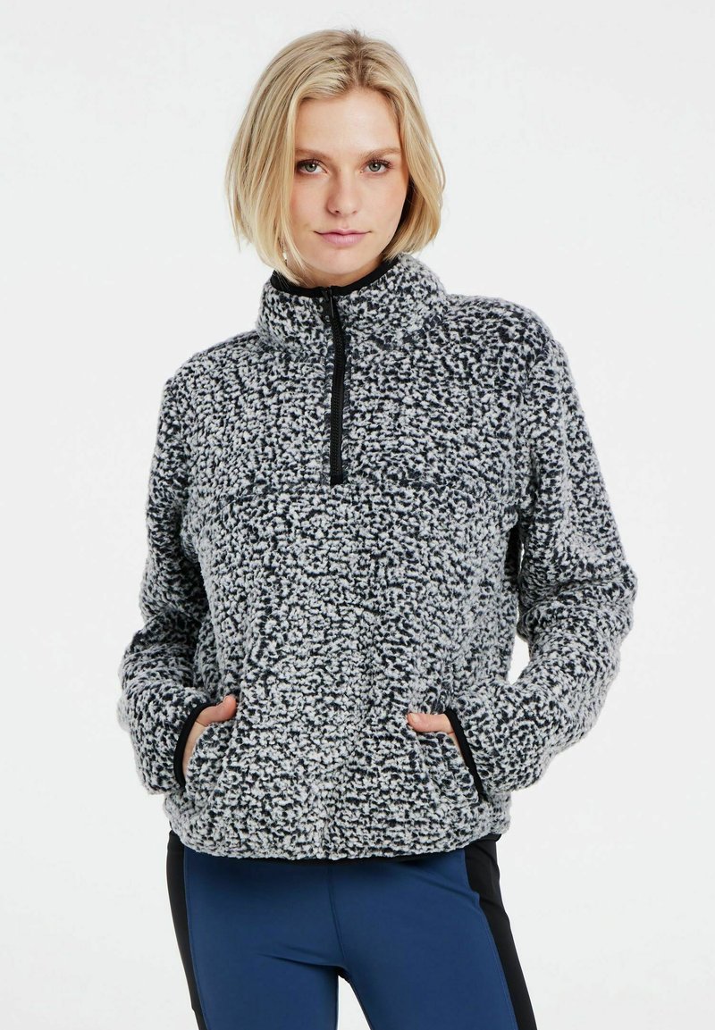 Fleece-Pullover aus schwarzem und weißem strukturiertem Stoff mit einem Reißverschlusskragen, seitlichen Taschen und Kontrastbesatz entlang der Bündchen und des Saums.