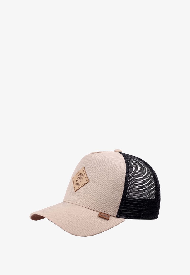 Beige és fekete hálós baseball sapka bőr logóval az elején és kis bőr címkével a karimán, fehér háttér előtt.