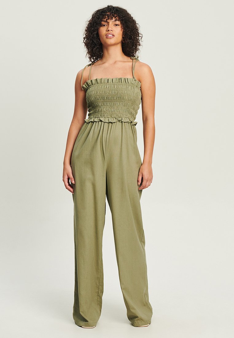 Olijfgroen jumpsuit met een gerimpelde corsage, gerimpelde afwerking, dunne verstelbare bandjes en wijde pijpen van lichtgewicht stof.