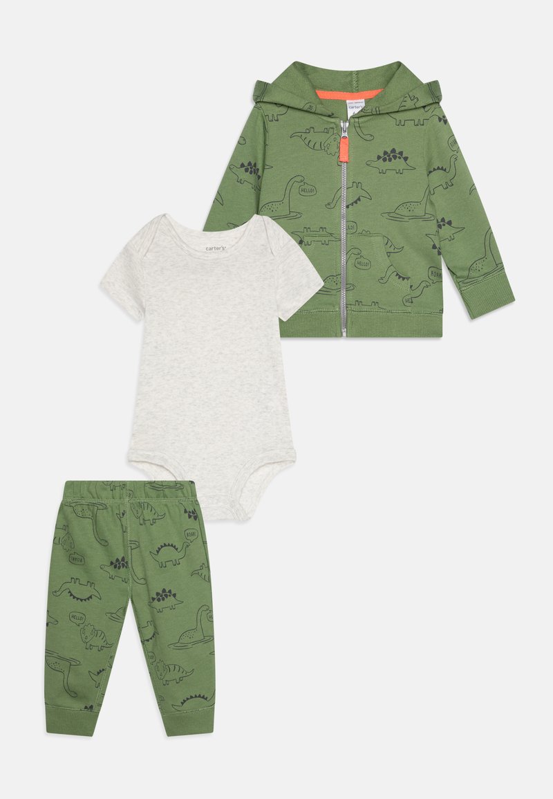 Žalias zip-up gobtuvas su dinozaurų atspaudais, derinamas su šviesiai pilku trumpomis rankovėmis bodžiu ir atitinkančiomis žaliomis kelnėmis su panašiais raštais.