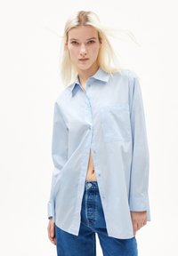 Lichtblauwe langefsleevige button-up shirt van katoen, met een enkele borstzak en een relaxte pasvorm met een afgeschuind hem.