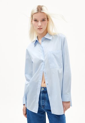 Camicia azzurra a maniche lunghe con bottoni in tessuto di cotone, dotata di una tasca sul petto e di una vestibilità rilassata con orlo curvo.