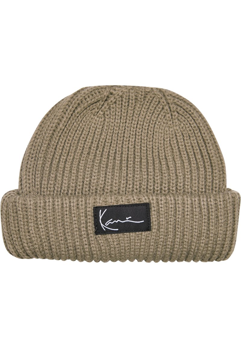 Beanie i olivengrønn, ribbet strikketekstur, med et svart stoffmerke med hvit signatur. Brettet mansjett for justerbar passform.