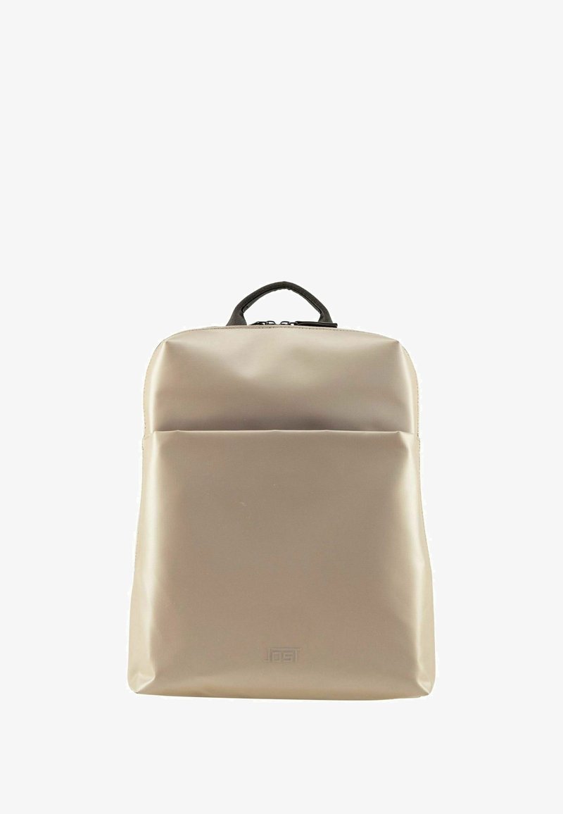 Zaino impermeabile beige con manico superiore, tasca frontale, texture liscia e design minimalista con branding discreto nella parte anteriore bassa.