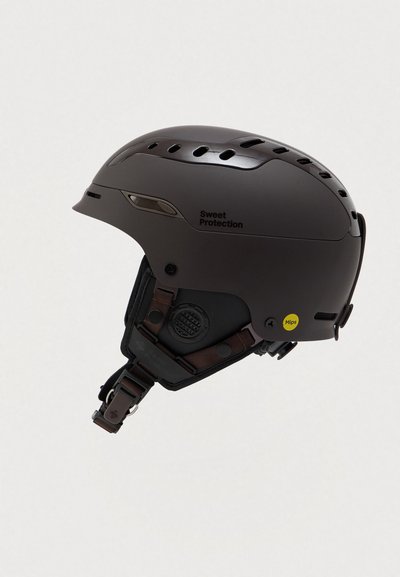 Brun hjelm med ventilationshuller, justerbart remsystem og MIPS-teknologiklæb. Har logo på siden og struktureret overflade.