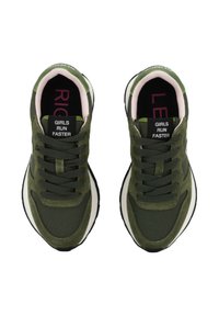 Un par de zapatillas verde olivo con cordones negros y el texto "LAS CHICAS CORREN MÁS RÁPIDO" en la lengüeta, vistas desde arriba.