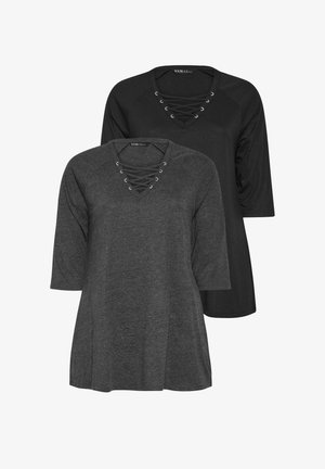 To toppe med lange raglanærmer og V-udskæringer med krydsbinding. Den ene er sort, den anden er mørkegrå, begge med en blød tekstur.