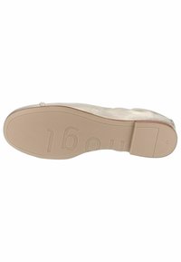 Suola di scarpa piatta in beige chiaro, con un accento trasparente, texture liscia e numeri in rilievo per l'identificazione della taglia e del marchio.