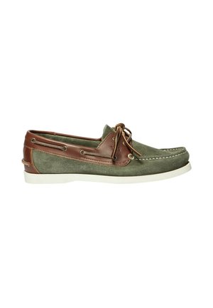 Chaussure bateau en daim vert et cuir marron avec semelle blanche et détails de lacets vue de côté sur fond blanc.