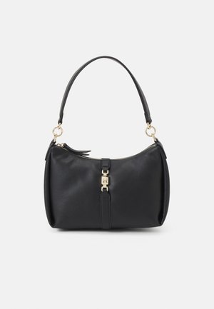 Sac à main en cuir noir avec une bandoulière simple, une quincaillerie dorée et une boucle décorative centrale, sur un fond blanc uni.