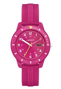 Montre en silicone rose avec un boîtier rond, aiguilles jaunes et blanches, marqueurs d'heure de 12 heures et logo de crocodile Lacoste sur le cadran. Bracelet texturé.