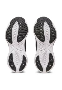 Sole di scarpe sportive in gomma nera caratterizzate da un design testurizzato con dettagli bianchi, scanalature e zone rialzate per una presa e una trazione migliori.