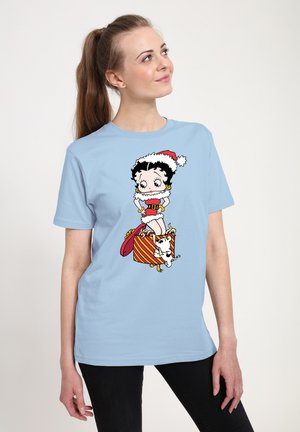 T-shirt azzurro chiaro con una grafica giocosa di Betty Boop in abbigliamento festivo, con un cappello di Natale, che si trova sopra una scatola regalo a righe e un cane.