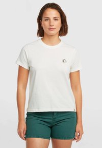 White cotton t-shirt with short sleeves, featuring a round neckline and a small round logo on the left chest. Paired with green shorts.
