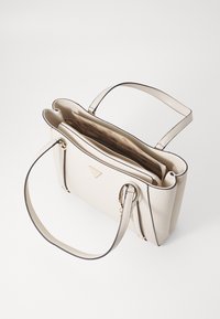 Borsa beige con design strutturato, pelle liscia, bordi neri a contrasto, doppi manici e tasca interna con zip.