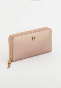 Różowy portfel z materiału syntetycznego o fakturowanym wykończeniu, zamykany na suwak, z elementami w kolorze złotym i prostokątną ozdobą z przodu.