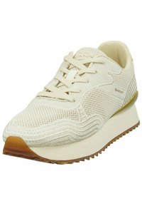 Weißer Sportschuh mit strukturiertem Strick-Obermaterial, rundem Zehenbereich, flachen Schnürsenkeln und einer leicht erhöhten Gummisohle mit einem Profilmuster.