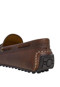 Bruna läderloafers med texturerad yta, sömnadsdetaljer och gummisula. Har en rundad bakdel med en diskret logotypaccent.