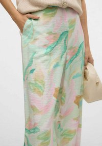 Pantaloni leggeri di colore pastello con motivi floreali in tonalità di verde, rosa e oro; tessuto tessurizzato; tasche laterali; vestibilità rilassata.