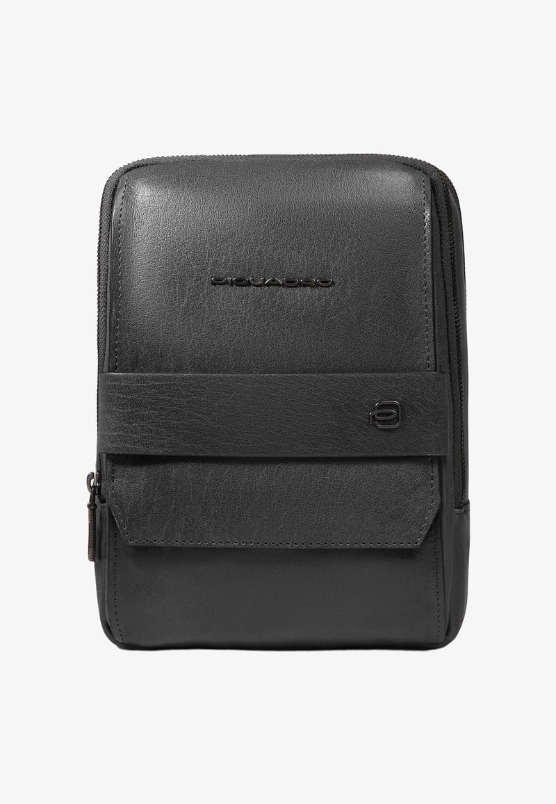 Sac bandoulière compact en cuir noir avec poche à rabat sur le devant, fermeture éclair et logo de la marque embossé sur le panneau avant.