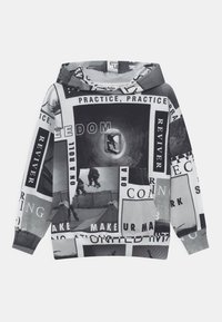 Felpa nera e bianca con foto di skateboard e blocchi di testo che includono "Pratica", "Libertà" e "Rivitalizzante" in un design a collage.