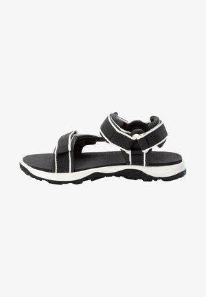 Schwarze Sandale mit weißen Akzenten, ausgestattet mit einer strukturierten Sohle, verstellbaren Riemen und einem minimalistischen Design. Offene Zehen und Fersen sorgen für Atmungsaktivität.