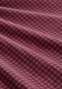 Textielstof in diep bordeauxrood met een subtiel ruitpatroon, waarbij verschillende tinten textuur en diepte in het ontwerp creëren.