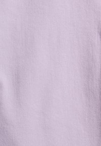 Levandulová látka s jemnou diagonální tkaninou. Měkký, lehký materiál bez viditelných vzorů nebo kovových doplňků.