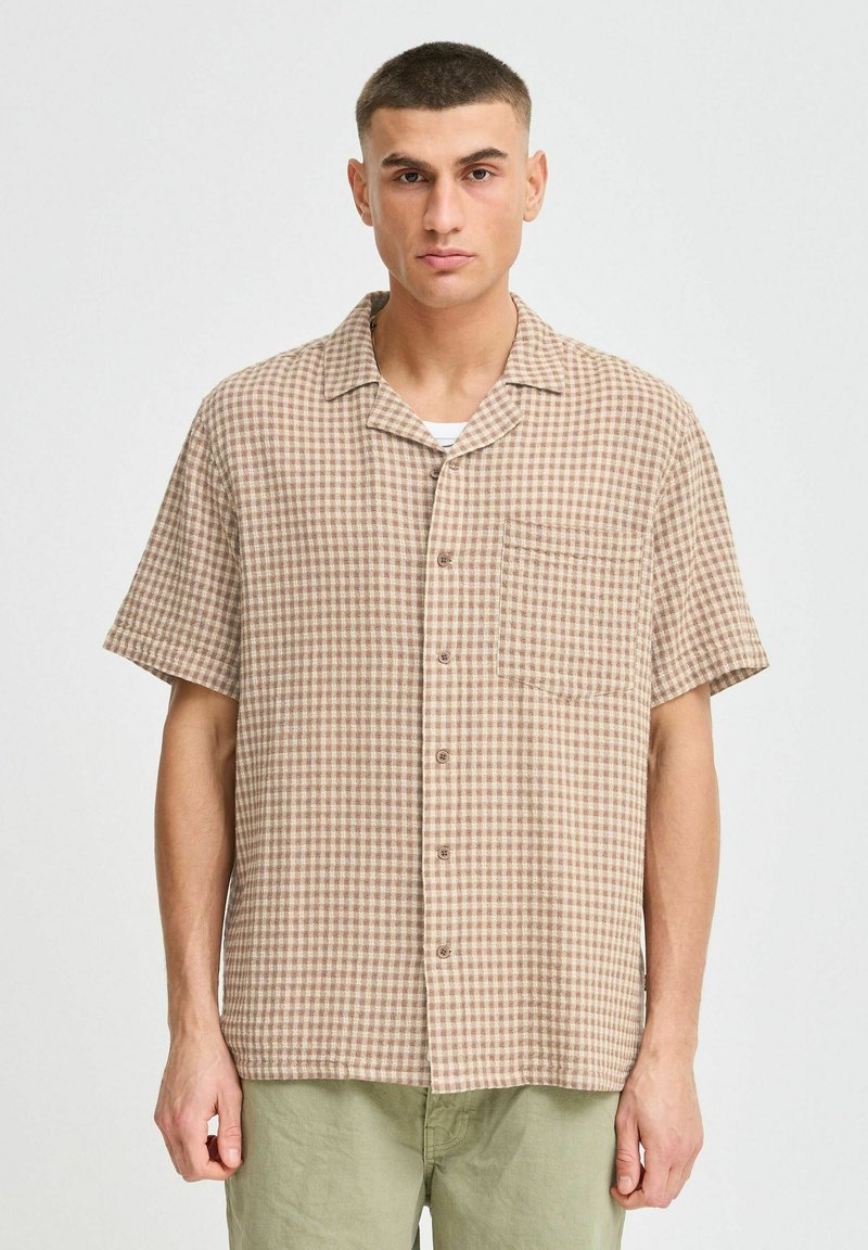 Short-sleeve checked shirt in brown and beige. Made of lightweight fabric, features a button-up front and a chest pocket.