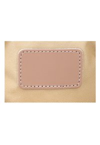 Rectangular light brown leather patch with white stitching on beige textured fabric background.