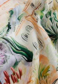 Țesătură cu model floral ce prezintă culori vibrante, inclusiv verde, roz și portocaliu, având o textură ușoară și semi-transparentă.