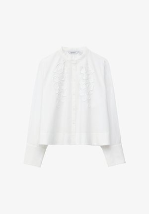 White long-sleeve blouse with a mandarin collar, front button closure, wide cuffs, and raised floral embroidery on both sides of the chest.