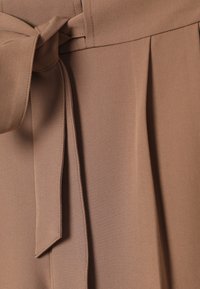 Tissu marron à texture lisse, doté d'une ceinture nouée et de plis à l'avant. Le design est simple, sans motifs ni accessoires supplémentaires.