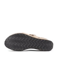Infradito beige con suola in gomma nera a motivo ondulato. Presenta una punta arrotondata e una cinghia regolabile con hardware in metallo per una vestibilità sicura.