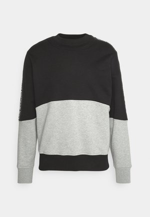 Sweatshirt med en sort øverste sektion og en grå nederste sektion. Har ribbet krave og manchetter, med trykt detalje langs venstre ærme.