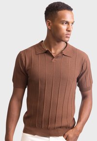 Braun gestricktes Polo-Shirt mit kurzen Ärmeln, vertikalen Rippen, einem Kragen und einem V-Ausschnitt, aus strukturiertem Stoff gefertigt.