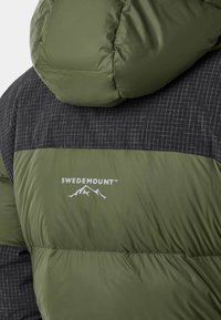Puffer jacket in olive green and black. Features a grid pattern, smooth texture, and a logo print. Hooded with a quilted design.