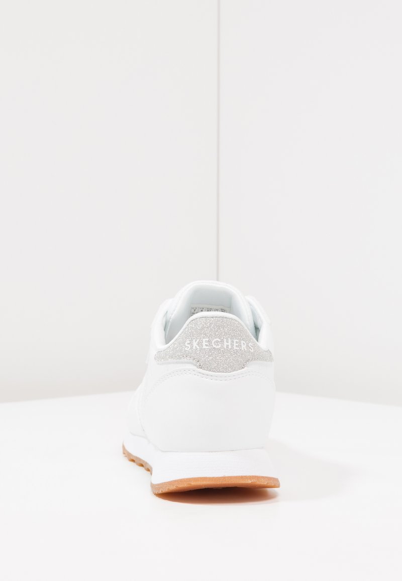 Witte Skechers sneaker met een gladleren bovenwerk, zilveren accenten op de hiel en een lichtbruine rubberen buitenzool.