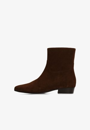 Bottine en daim marron avec bout pointu et petit talon bloc, vue de côté sur fond blanc.