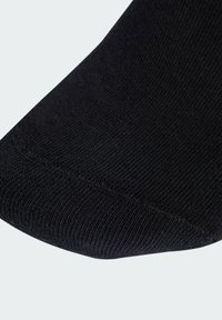 Black ankle sock with ribbed texture, smooth toe seam, and even stitching. Material appears stretchy and durable.