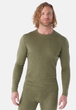 Long-sleeve thermal shirt in olive green, made from a soft, textured fabric. Features a crew neck, fitted design, and subtle logo on the sleeve.