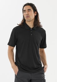 Sort polo-shirt lavet af blød, letvægtsstof. Har en foldet krave, tre-knap lukning og korte ærmer.
