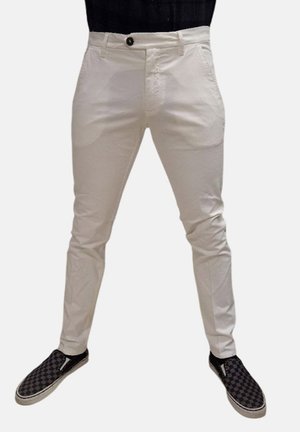 Pantaloni slim-fit di colore crema realizzati in tessuto traspirante, con tasche laterali, chiusura con un unico bottone e dettagli di cucitura su misura.