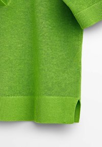 Pull en maille vert vif à manches courtes montrant une texture détaillée, un ourlet côtelé et une fente latérale sur fond blanc uni.