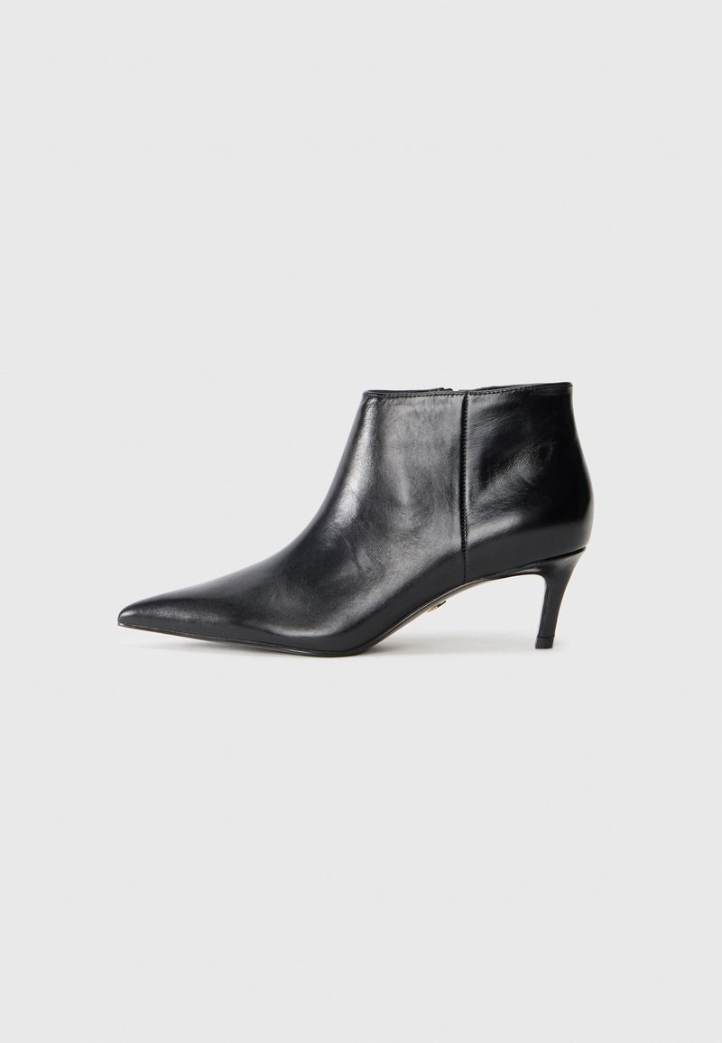 Botte de cheville en cuir noir avec un bout pointu et un talon moyen élancé, présentée en profil latéral sur fond blanc.
