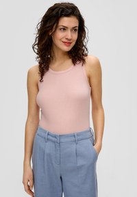 Helles, rosa, geripptes Tanktop mit rundem Halsausschnitt, kombiniert mit hellblauen, maßgeschneiderten Hosen mit seitlichen Taschen und lockerer Passform.