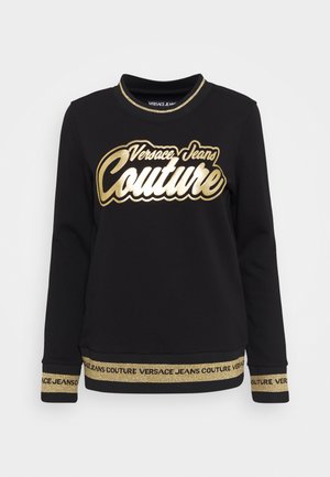 Czarna bluza z długim rękawem z złotym logo "Versace Jeans Couture" na piersi oraz złotymi lamówkami na mankietach i dole, zawierającymi powtarzający się tekst marki.